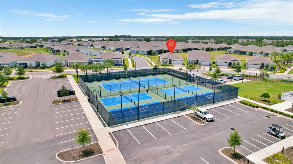 An aerial view shows a fenced pickleball court complex next to a parking lot — 13175 SUNNY RETREAT LANE, WINTER GARDEN, FL