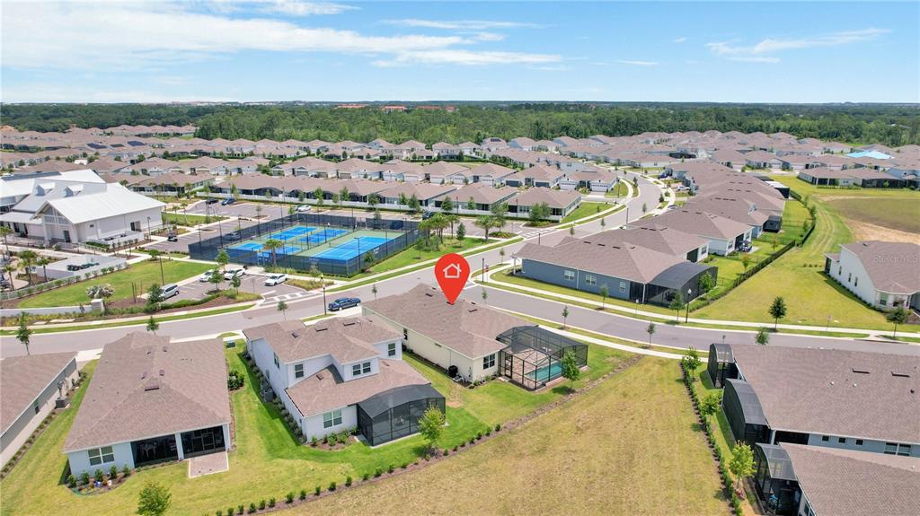 An aerial view shows a residential neighborhood with a marked house featuring a screened pool — 13175 SUNNY RETREAT LANE, WINTER GARDEN, FL