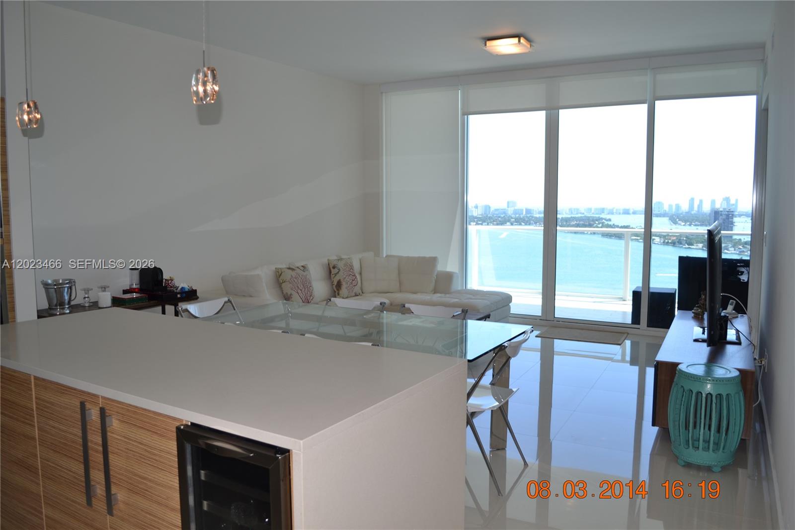 A modern living and dining area features a glass table, white sofa, and balcony view — 2020 N Bayshore Dr # 2805, Miami FL 33137, MIAMI, FL