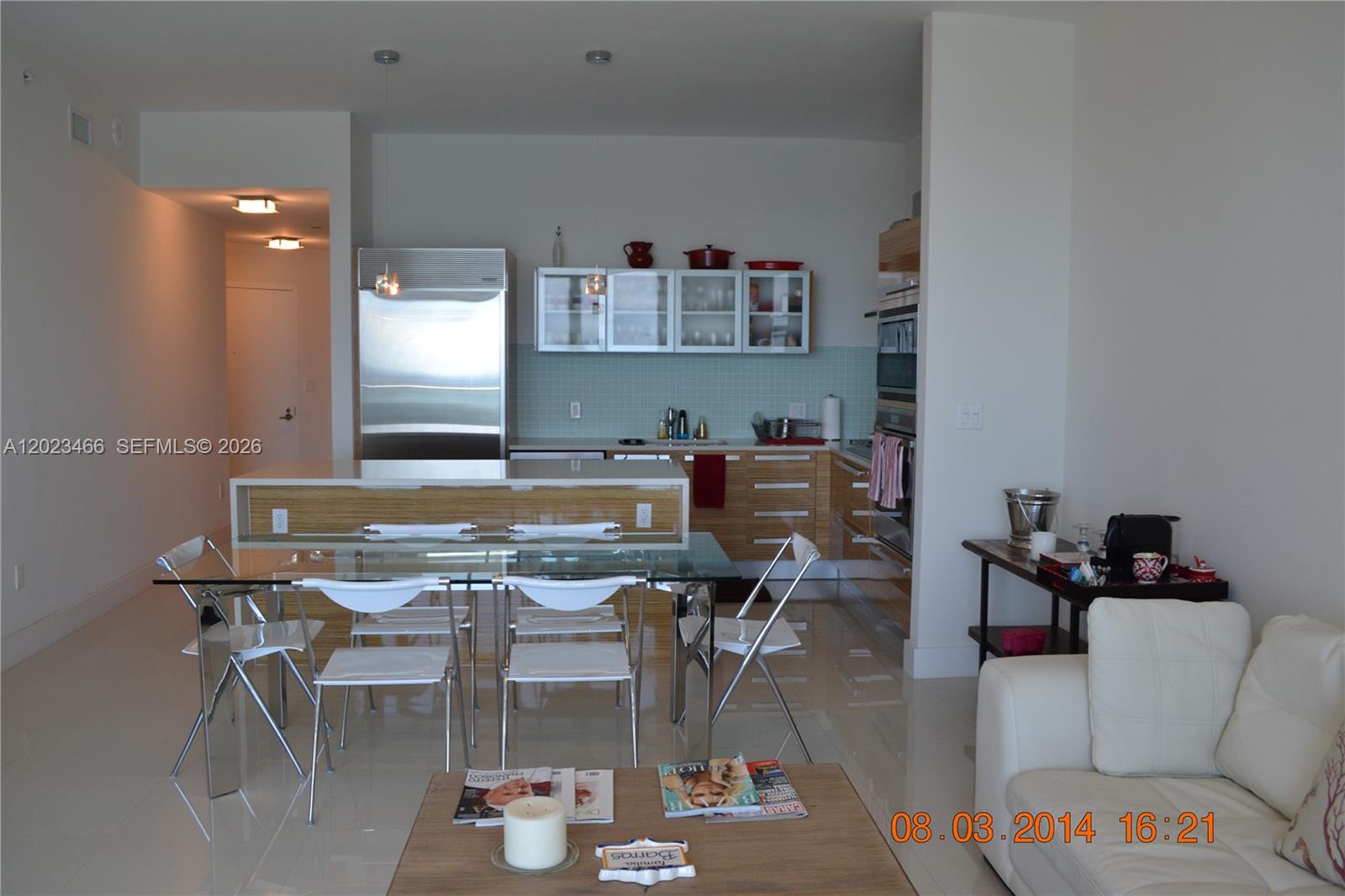 A modern kitchen features light wood cabinetry, stainless steel appliances, and a glass dining table — 2020 N Bayshore Dr # 2805, Miami FL 33137, MIAMI, FL