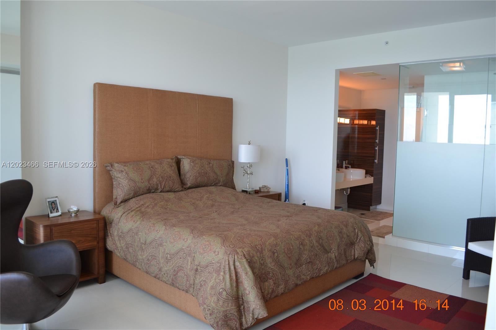 A bedroom features a paisley bedspread, a tall headboard, and an adjacent open-concept bathroom — 2020 N Bayshore Dr # 2805, Miami FL 33137, MIAMI, FL
