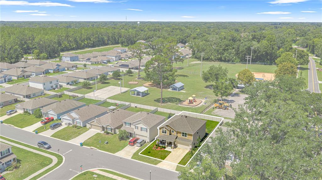 An aerial view shows a two-story house with a fenced yard next to a park — 826 NW 244TH DRIVE, NEWBERRY, FL