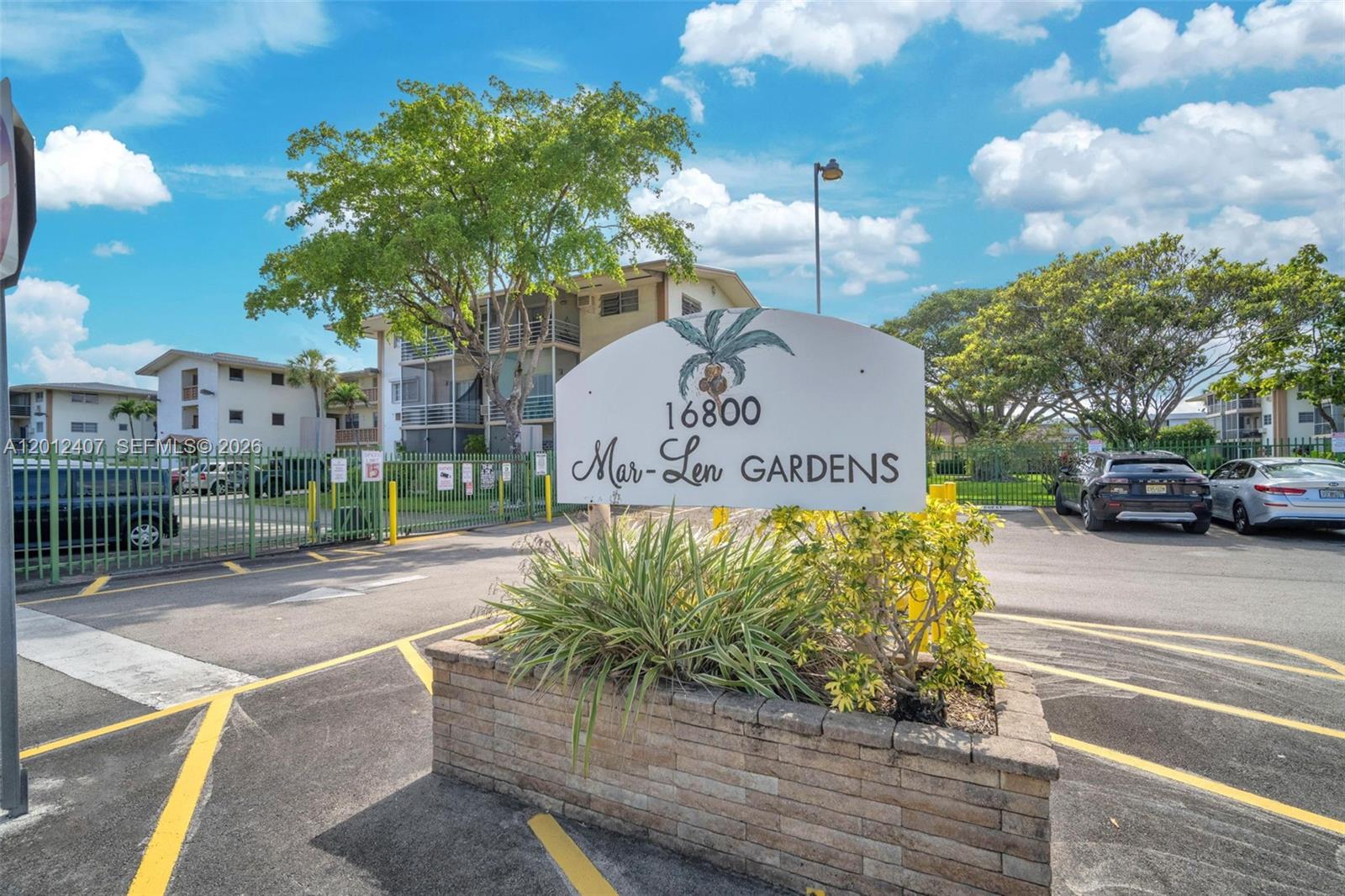 A sign for Mar-Len Gardens stands in front of a parking lot and apartment buildings — 16901 NE 13th Ave # 303, Miami FL 33162, MIAMI, FL