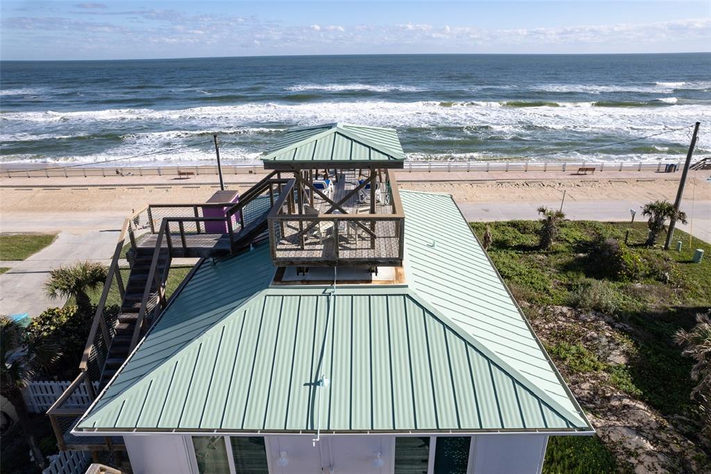 An aerial view of a house with a green metal roof and a rooftop deck — 6618 S ATLANTIC AVENUE, NEW SMYRNA BEACH, FL