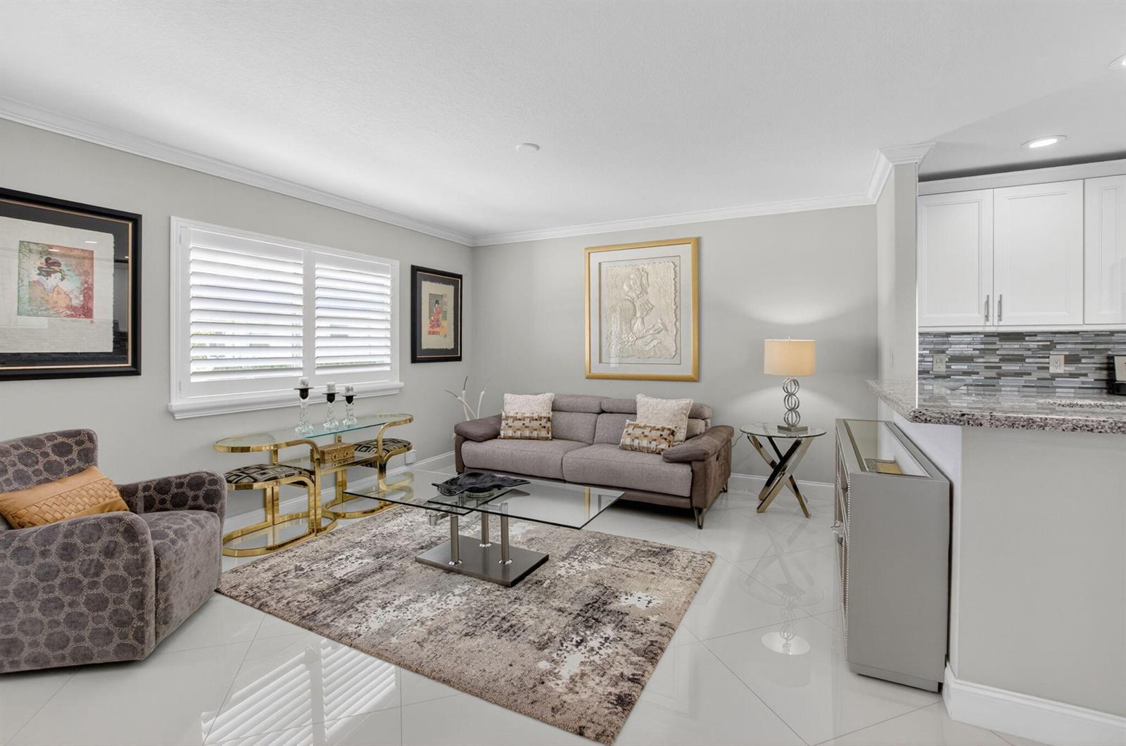 A living room features a grey sofa, glass coffee table, patterned rug, and white tile floors — 102 E Waterford E # 102, Delray Beach FL 33446, DELRAY BEACH, FL