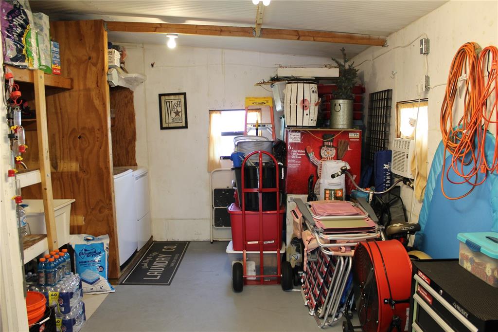 A utility room with a washer, dryer, storage shelves, and various household items — 6369 ELMWOOD AVENUE, LAKE WALES, FL