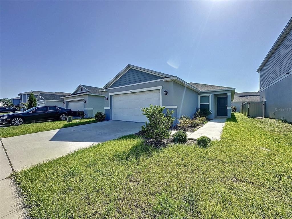 A single-story suburban house with a two-car garage, gray siding, and a concrete driveway — 707 SCRUB OAK HAMMOCK ROAD, DAVENPORT, FL