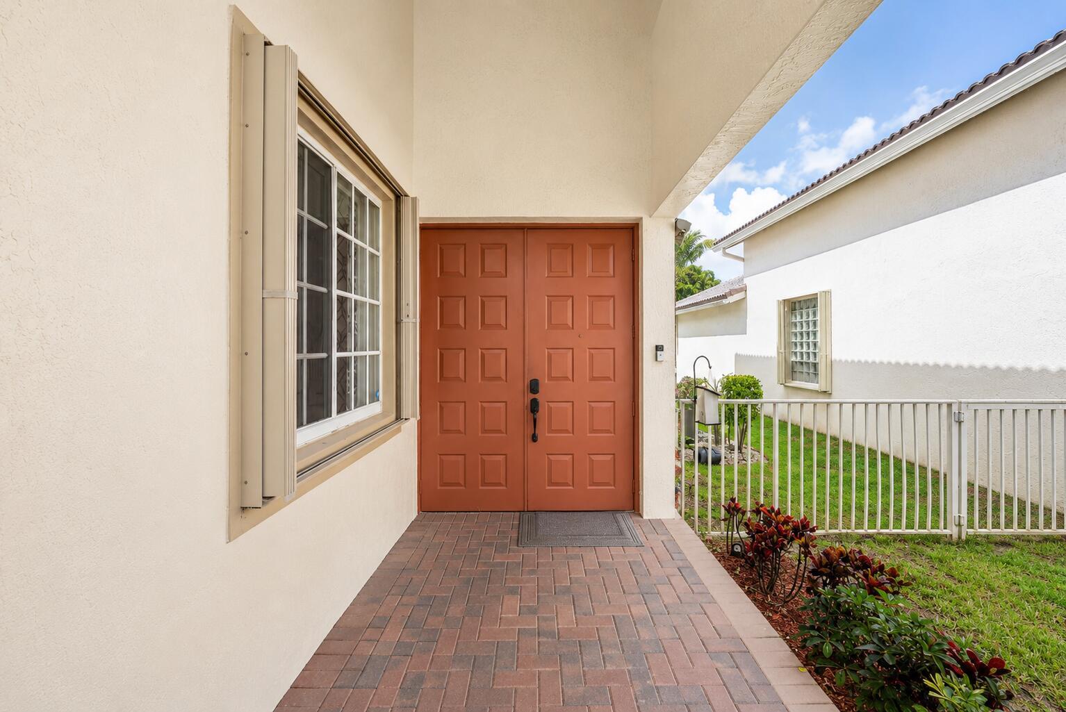 A brick walkway leads to a double front door under a covered entryway — 140 Bellezza Terrace, Royal Palm Beach FL 33411, ROYAL PALM BEACH, FL