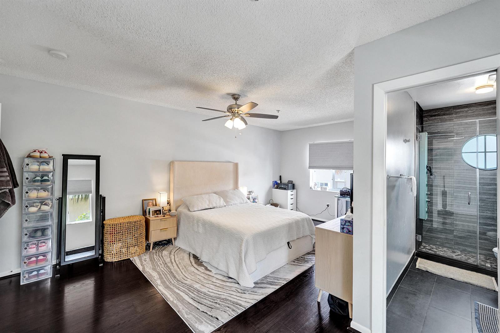 A bedroom with dark wood floors, a bed, a ceiling fan, and an attached bathroom — 173 Riviera Circle, Weston FL 33326, WESTON, FL