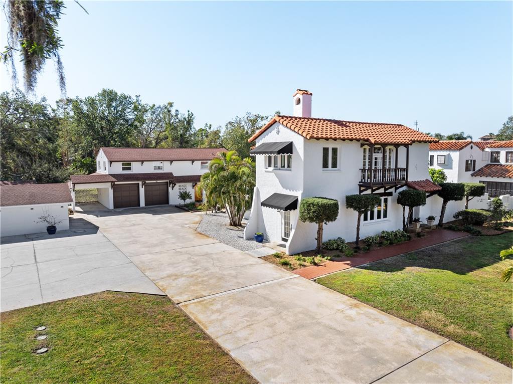 A white Mediterranean-style house with a red tile roof and a large concrete driveway — 6010 17TH AVENUE S, GULFPORT, FL