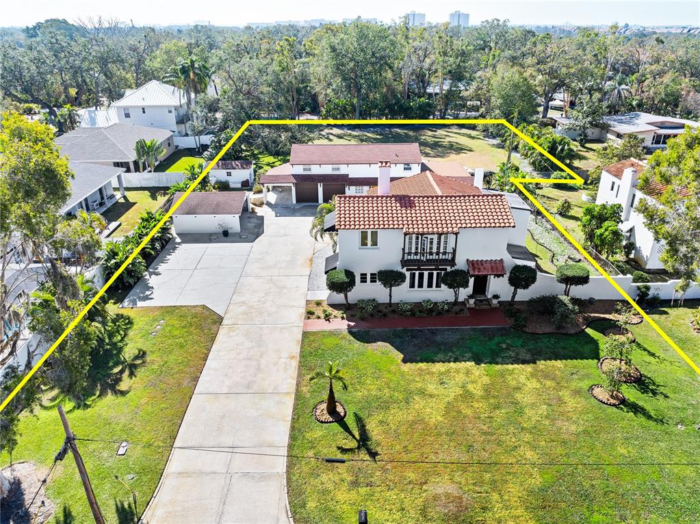 An aerial view shows a white house with a red tile roof and large yard — 6010 17TH AVENUE S, GULFPORT, FL
