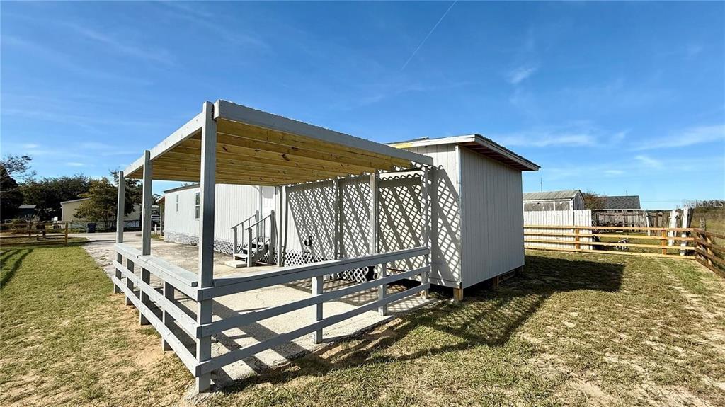 A mobile home features a wooden deck with a pergola and lattice privacy screen — 639 ELLISON PARKWAY, HAINES CITY, FL