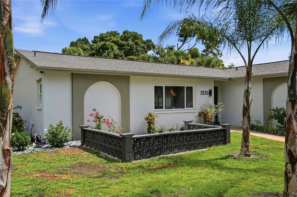 A single-story house exterior features a decorative concrete block wall and arched wall accents — 2235 ANASTASIA WAY S, ST PETERSBURG, FL