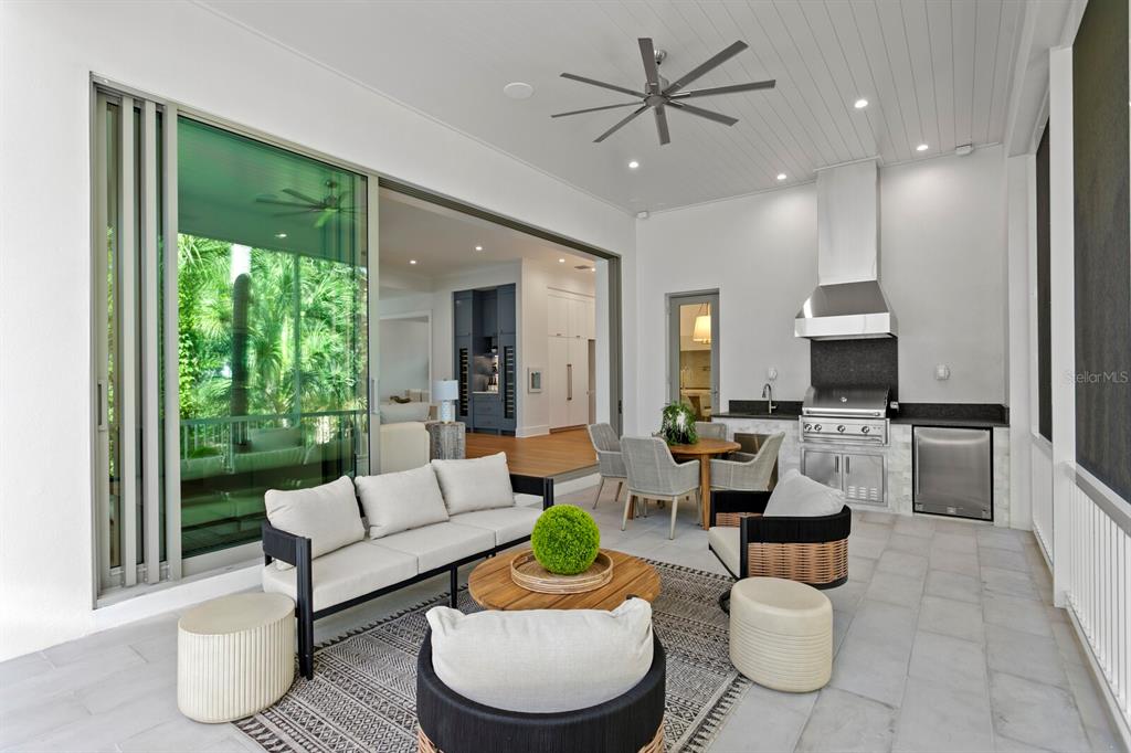A covered outdoor patio features a seating area, dining set, and a built-in stainless grill — 423 S ROYAL POINCIANA DRIVE, TAMPA, FL