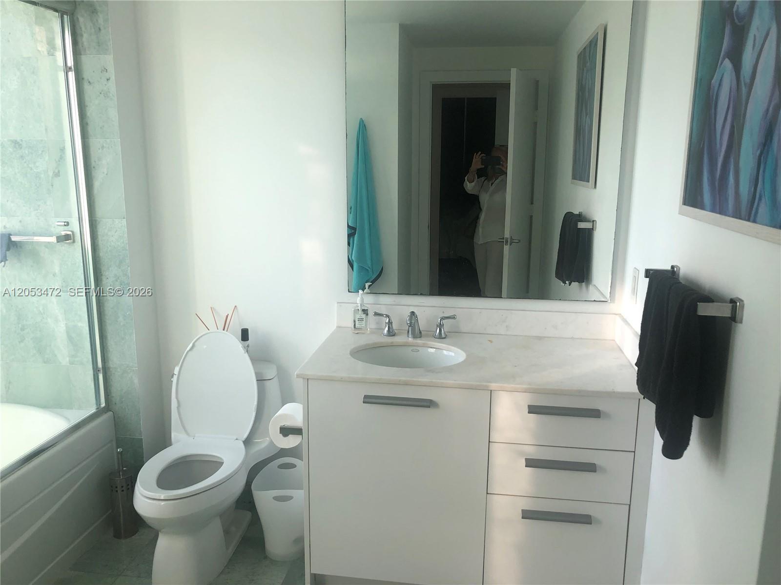 A bathroom features a white vanity with a marble countertop, a toilet, and a shower — 1050 Brickell Ave # 2910, Miami FL 33131, MIAMI, FL