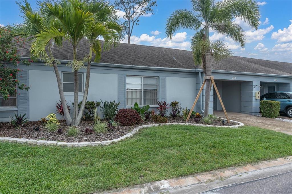 A single-story gray house features a landscaped front yard with palm trees and a driveway — 8236 BRENTWOOD ROAD, SEMINOLE, FL