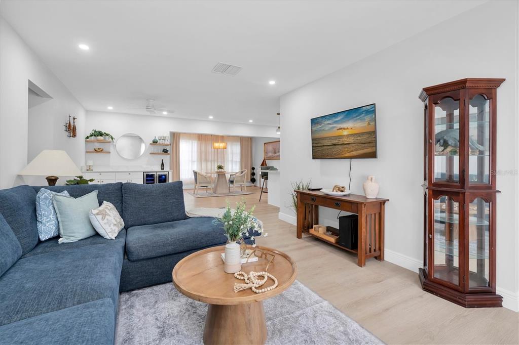 A living room features a blue sectional sofa, a wooden coffee table, and a corner cabinet — 8236 BRENTWOOD ROAD, SEMINOLE, FL