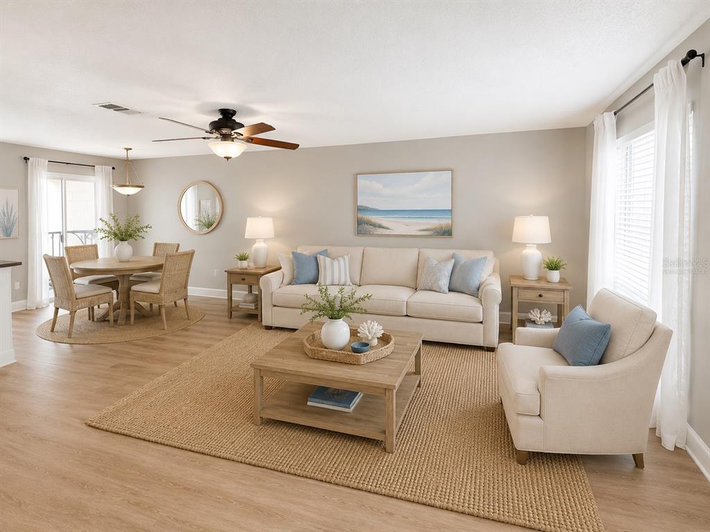A bright living and dining area features neutral furniture, light wood flooring, and coastal decor — 11905 CYPRESS VISTA, TAMPA, FL