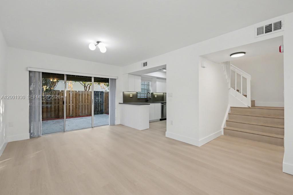 An open-concept living area features light wood flooring, a kitchen, and a staircase — 12224 SW 52nd Pl, Cooper City FL 33330, COOPER CITY, FL