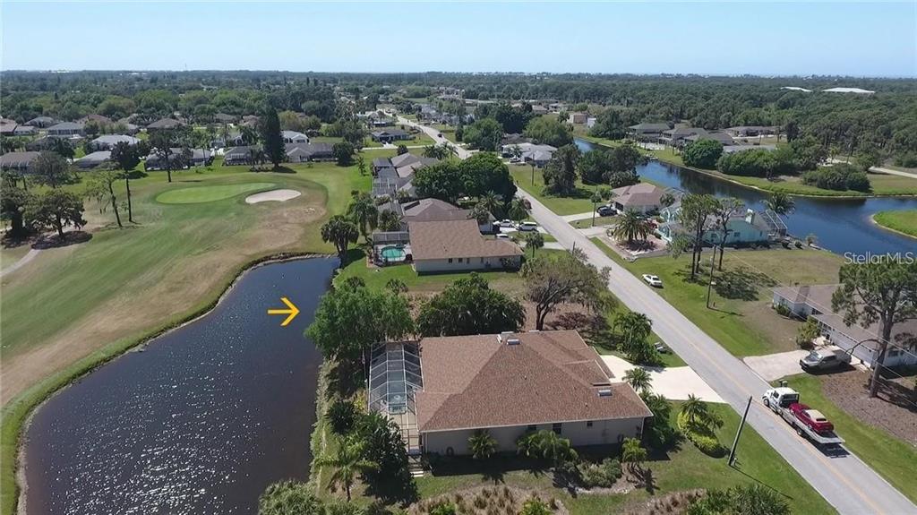 An aerial view shows a residential neighborhood with houses, a golf course, and a pond — 232 ROTONDA CIRCLE, ROTONDA WEST, FL