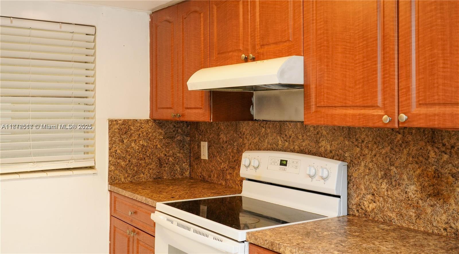 A kitchen features wood cabinets, a white range, and brown speckled laminate countertops — 11855 NE 19th Dr # 10, North Miami FL 33181, NORTH MIAMI, FL