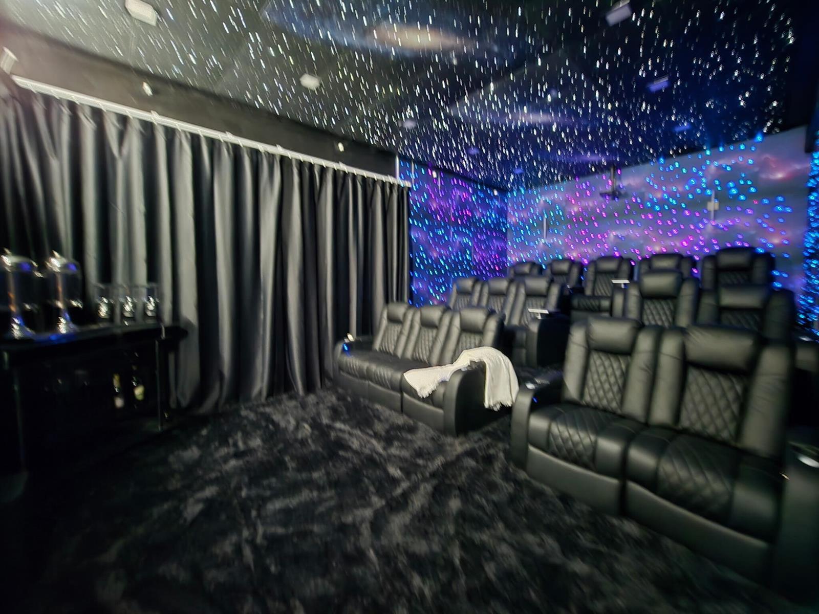 A home theater room features tiered leather seating, a star-patterned ceiling, and dark curtains — 377 Squire Drive, Wellington FL 33414, WELLINGTON, FL
