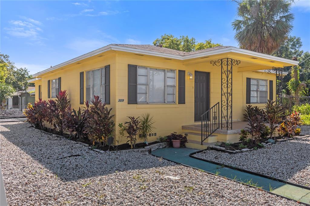 A yellow single-story house with a covered porch and gravel landscaping — 309 N 22ND STREET, TAMPA, FL