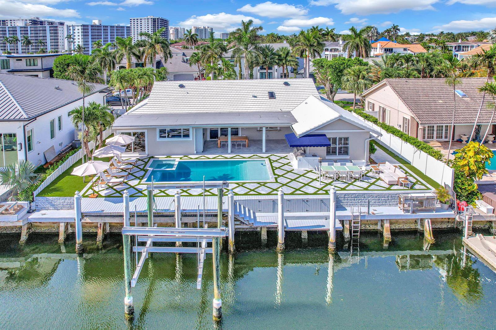 An aerial view of a waterfront house featuring a swimming pool, patio, and boat lift — 885 Nafa Drive, Boca Raton FL 33487, BOCA RATON, FL