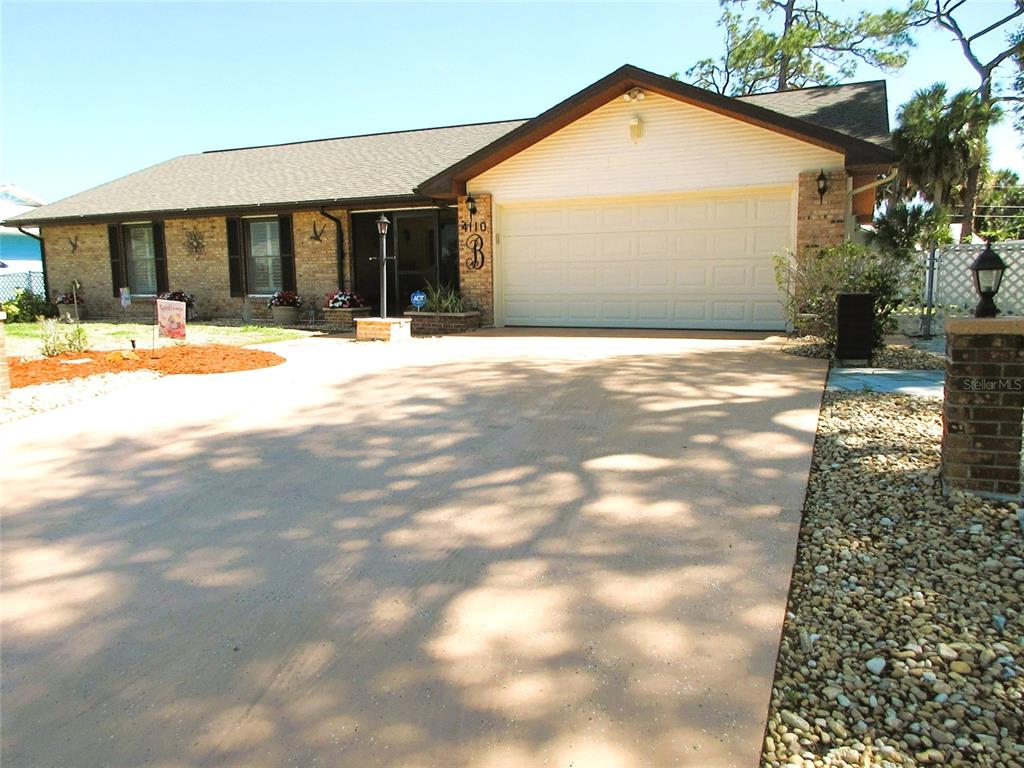 A single-story brick house features a two-car garage and a paved driveway — 4110 ALLURE LANE, NORTH PORT, FL