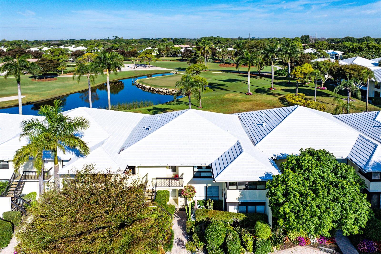 An aerial view of a multi-story residential building overlooking a golf course and pond — 3637 Quail Ridge Drive # A, Boynton Beach FL 33436, BOYNTON BEACH, FL