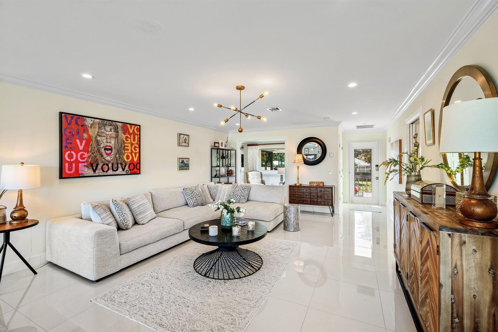 A bright living room features a large sectional sofa, a round coffee table, and tile flooring — 3637 Quail Ridge Drive # A, Boynton Beach FL 33436, BOYNTON BEACH, FL