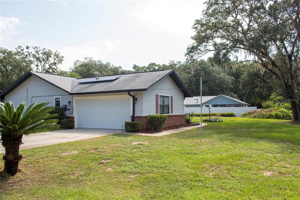 A single-story house with light gray siding, a brick base, and a white garage door — 5245 E FORT KING STREET STREET, OCALA, FL
