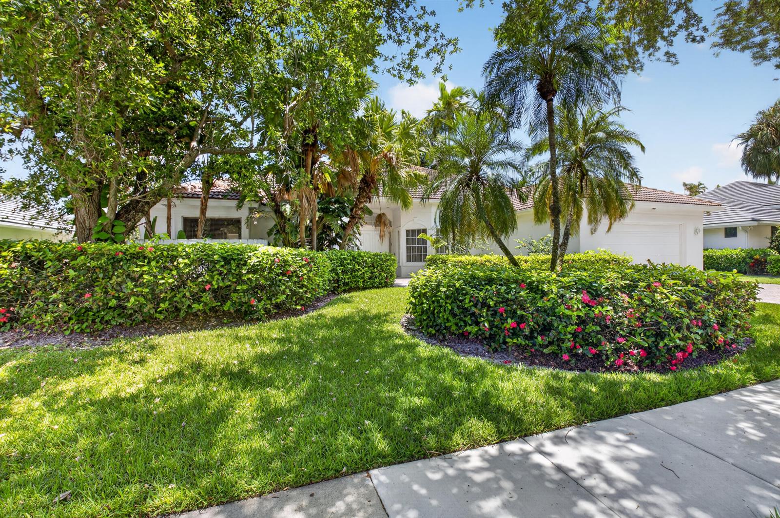 A white house with a tile roof is surrounded by lush landscaping and palm trees — 5768 Harrington Way, Boca Raton FL 33496, BOCA RATON, FL
