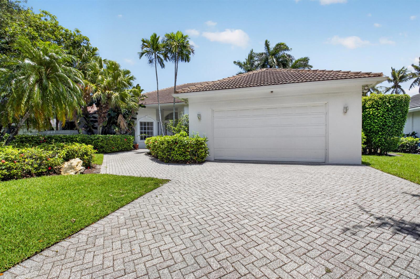 A white house with a tiled roof and a paved driveway surrounded by tropical landscaping — 5768 Harrington Way, Boca Raton FL 33496, BOCA RATON, FL