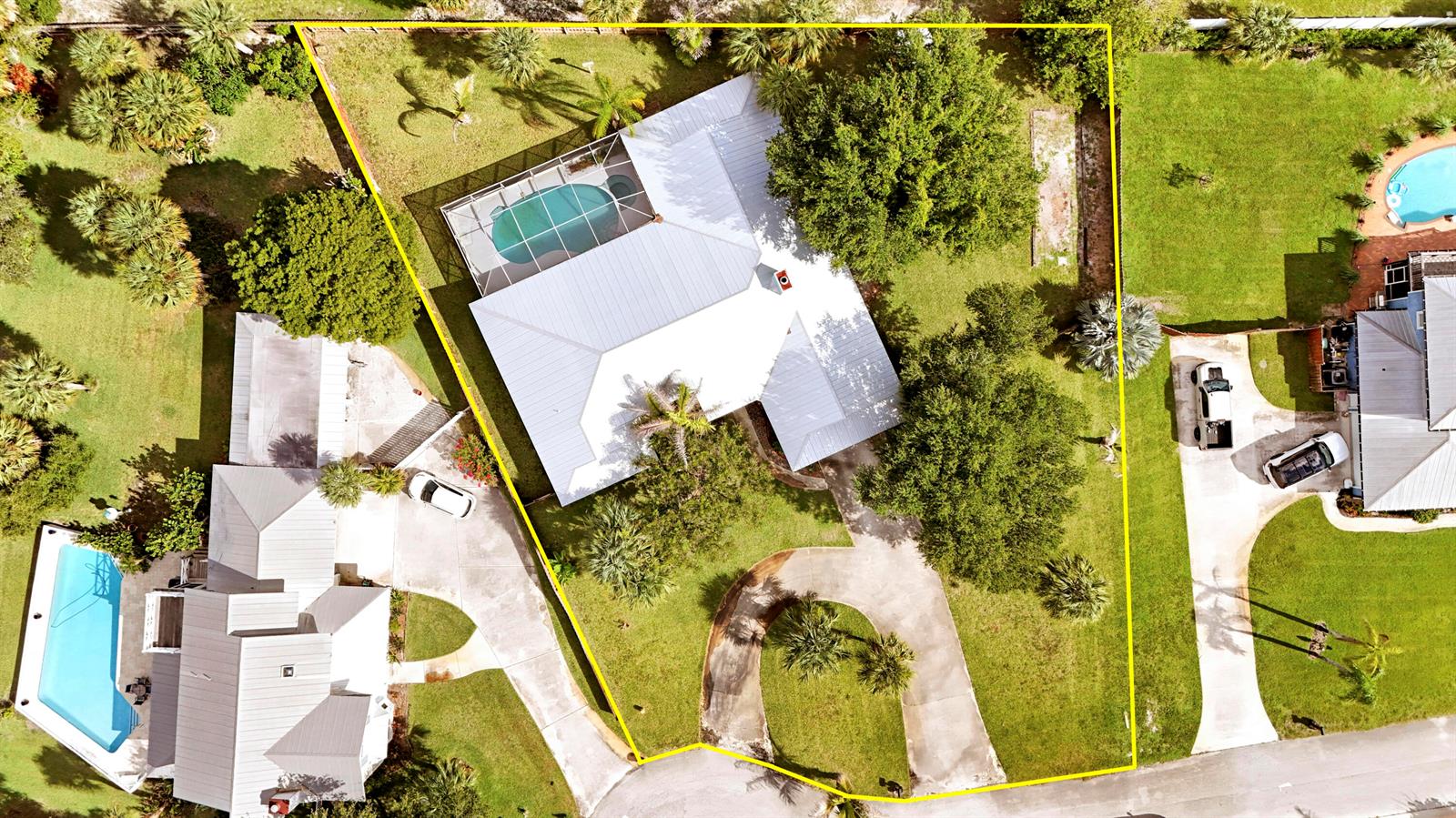 An aerial view shows a house with a pool enclosure, large trees, and a driveway — 12744 Refuge Lane, Jensen Beach FL 34957, JENSEN BEACH, FL
