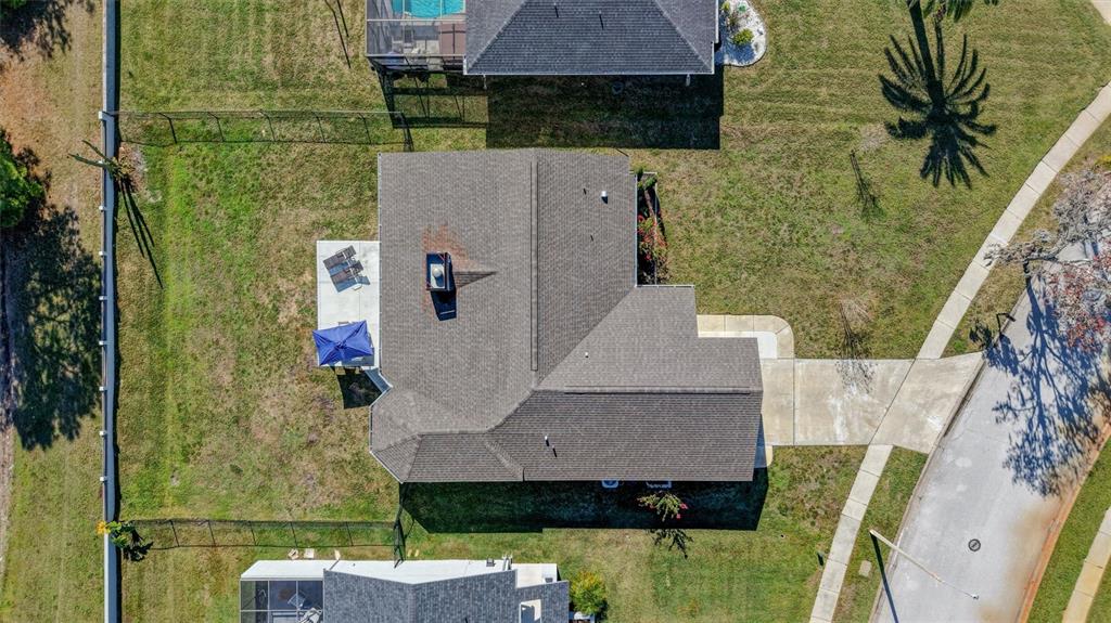 An aerial view shows a residential house with a shingled roof and a backyard patio — 3808 WATSON DRIVE, NEW PORT RICHEY, FL