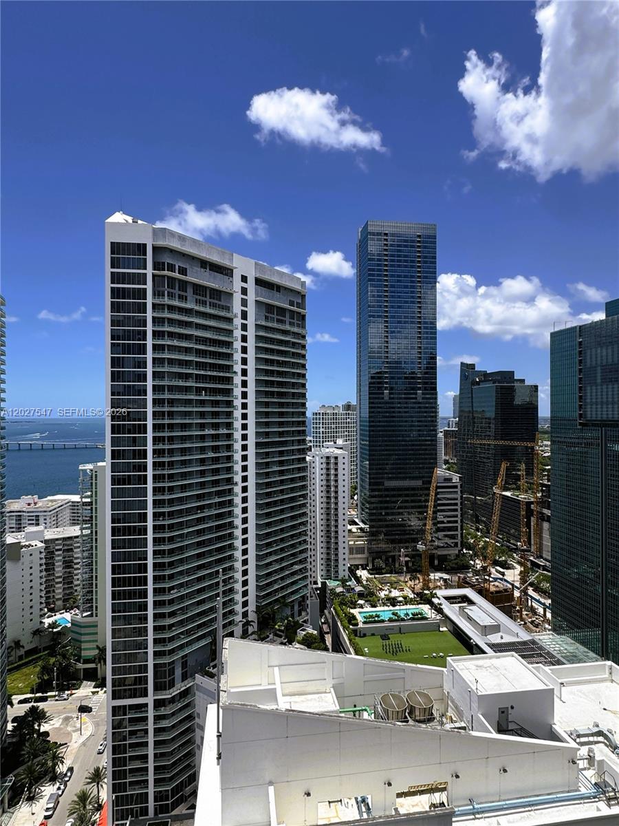 An elevated view shows several modern skyscrapers, a construction site, and a bay in Miami — 1200 Brickell Bay Dr # 3903, Miami FL 33131, MIAMI, FL