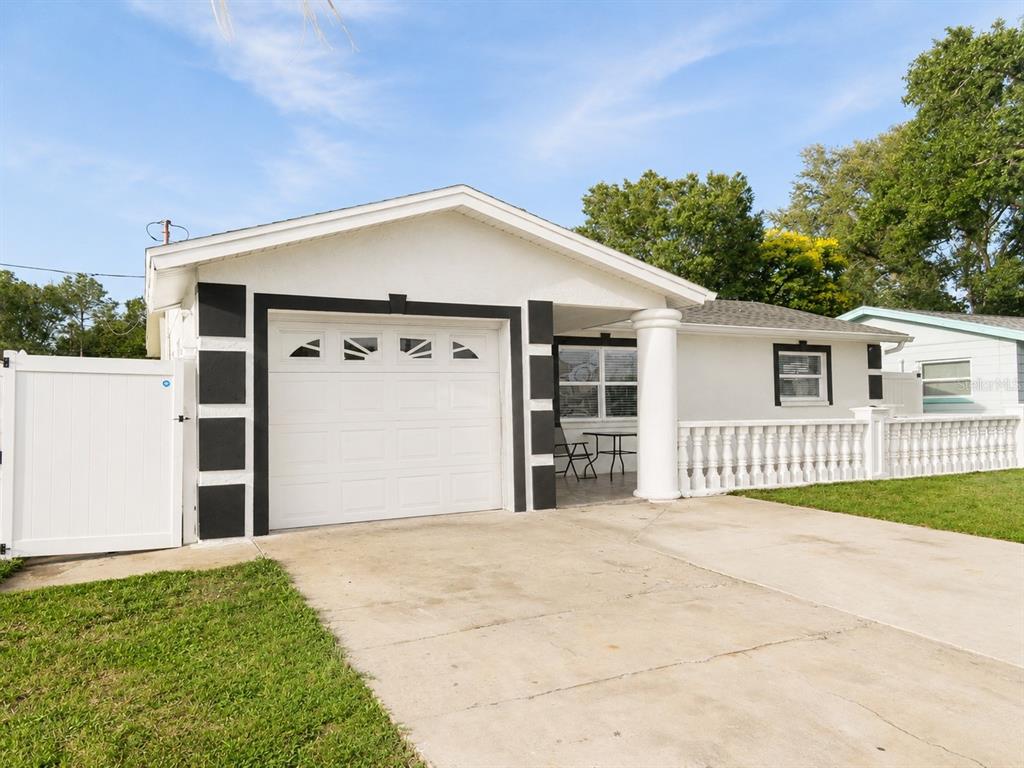 A white house with a garage, a front porch, and a white vinyl privacy fence — 4741 76TH AVENUE N, PINELLAS PARK, FL