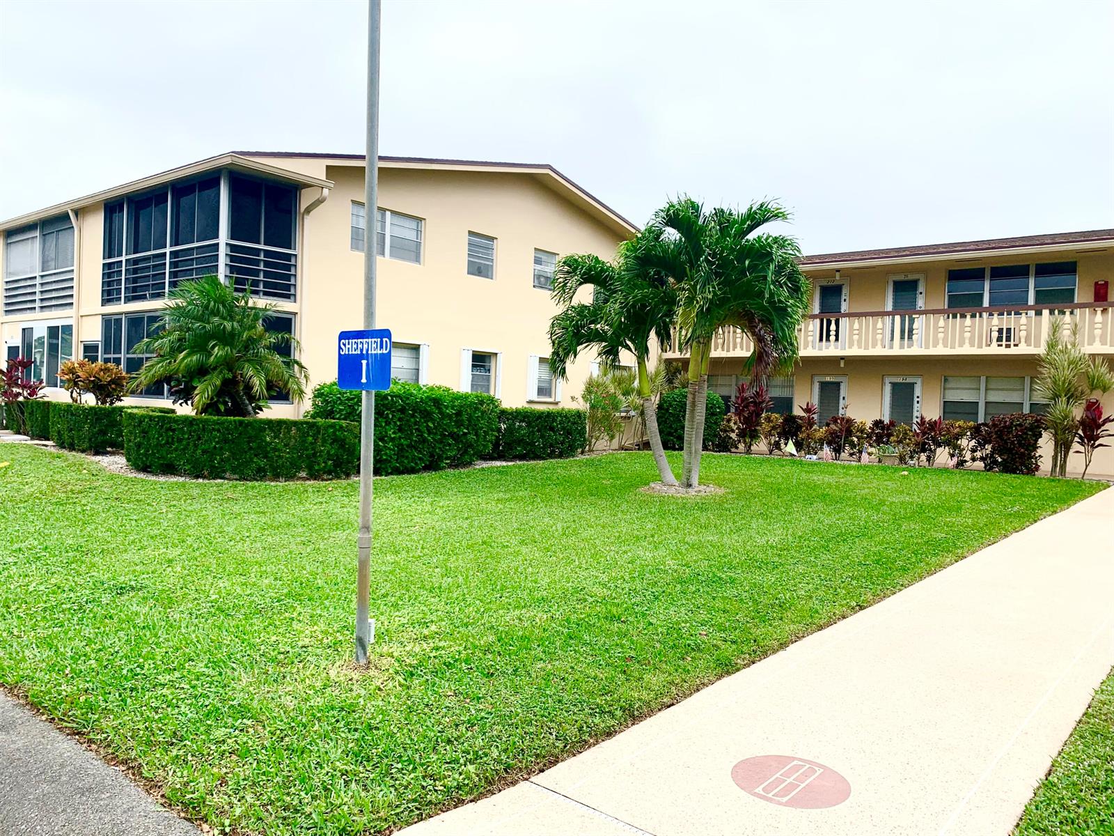 A two-story apartment building with a lawn, palm trees, and a Sheffield I sign — 200 Sheffield I, West Palm Beach FL 33417, WEST PALM BEACH, FL