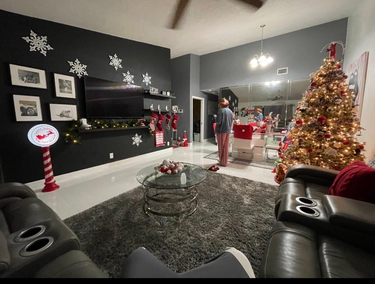 A living room features a black accent wall with a television, Christmas decor, and gray furniture — 7620 NW 38th Court, Sunrise FL 33351, SUNRISE, FL