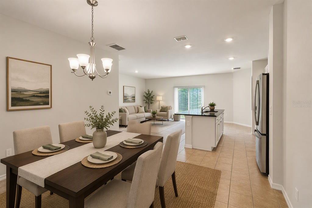 An open-concept dining area and living room with tile flooring and a kitchen island — 218 CAYUGA STREET, PORT CHARLOTTE, FL