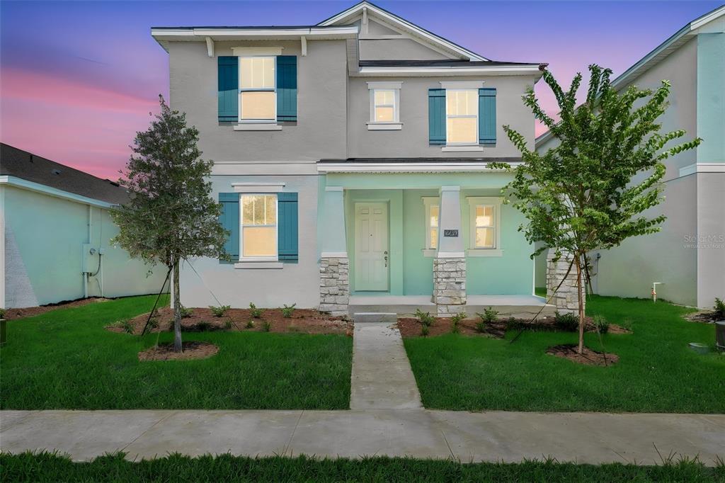 A two-story house with a light gray exterior, teal shutters, and a covered front porch — 5229 WAYPOINTE BOULEVARD, APOPKA, FL
