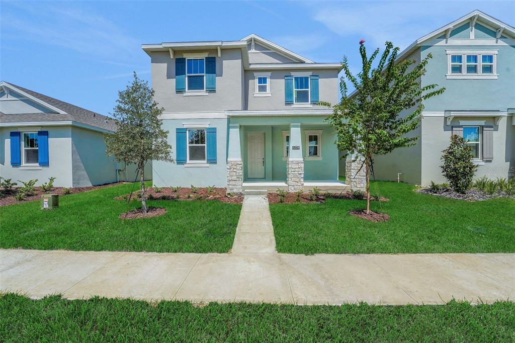 A two-story house with a covered front porch, stone accents, and blue shutters — 5229 WAYPOINTE BOULEVARD, APOPKA, FL