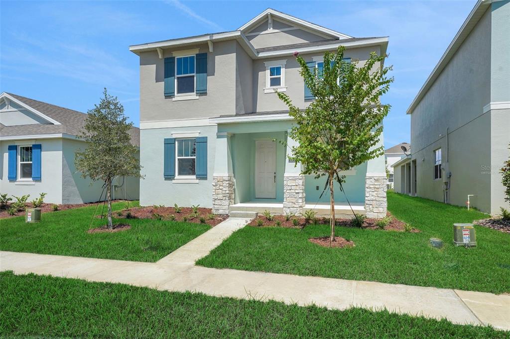 A two-story house with a light blue and gray exterior, stone accents, and blue shutters — 5229 WAYPOINTE BOULEVARD, APOPKA, FL