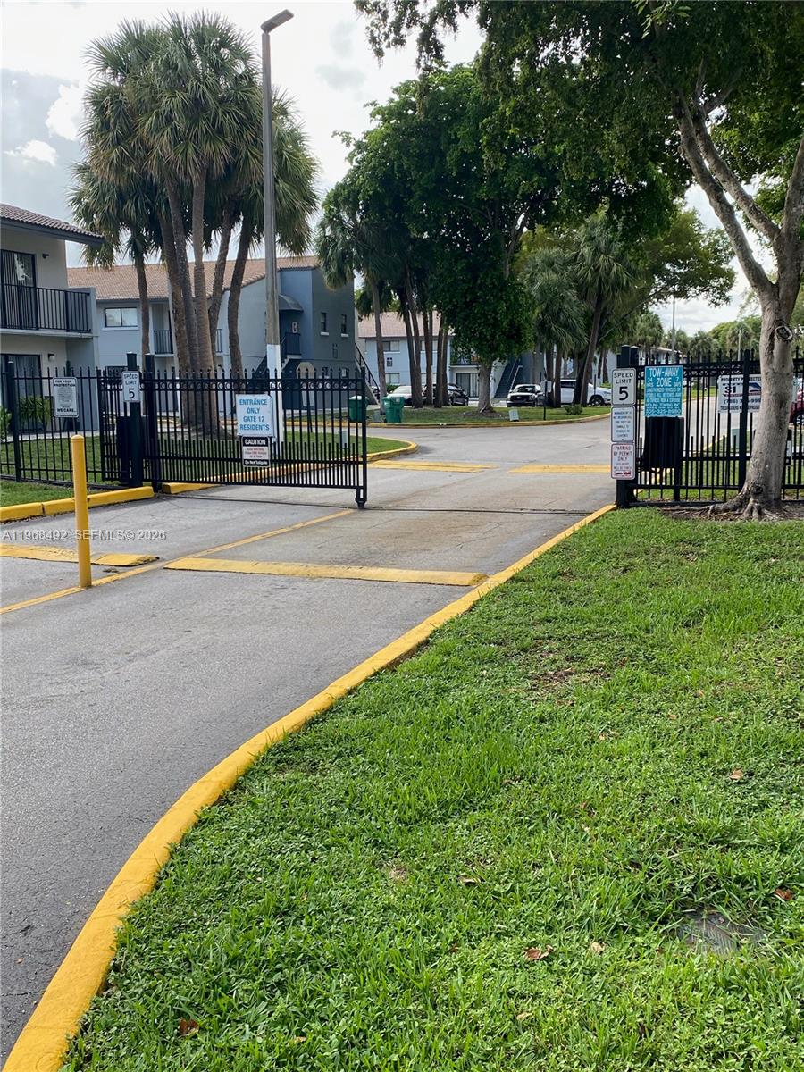 A gated entrance to an apartment complex features a speed bump and signage — 7030 NW 179th St # 205, Hialeah FL 33015, HIALEAH, FL