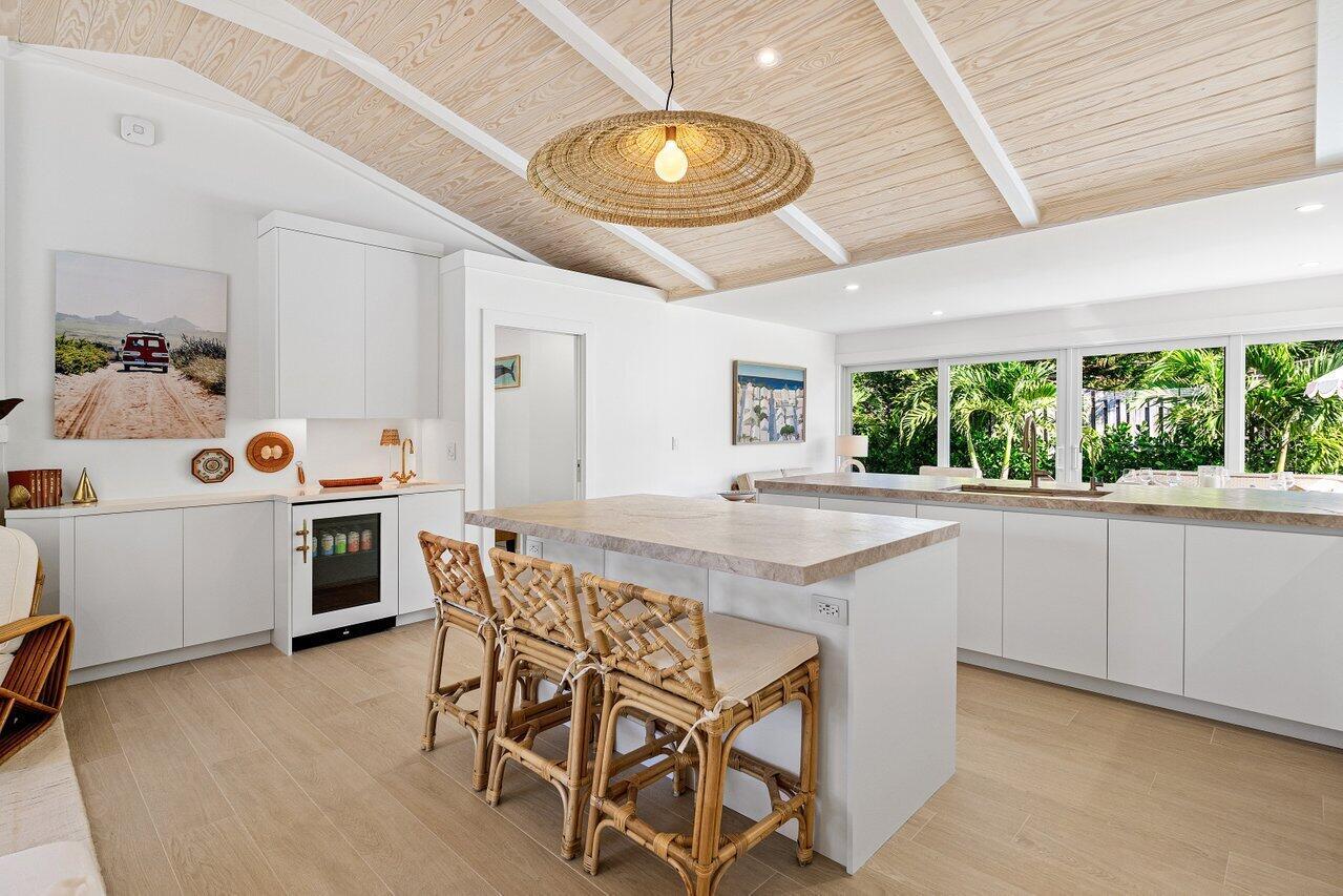 A bright kitchen features a wooden vaulted ceiling, a central island, and white cabinetry — 11 Hersey Drive, Ocean Ridge FL 33435, OCEAN RIDGE, FL