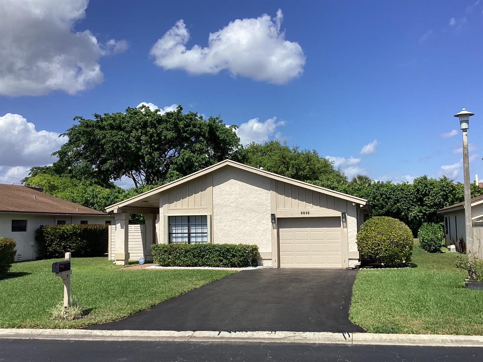 A single-story house with a beige stucco exterior, a garage, and a paved driveway — 8895 Old Pine Road, Boca Raton FL 33433, BOCA RATON, FL