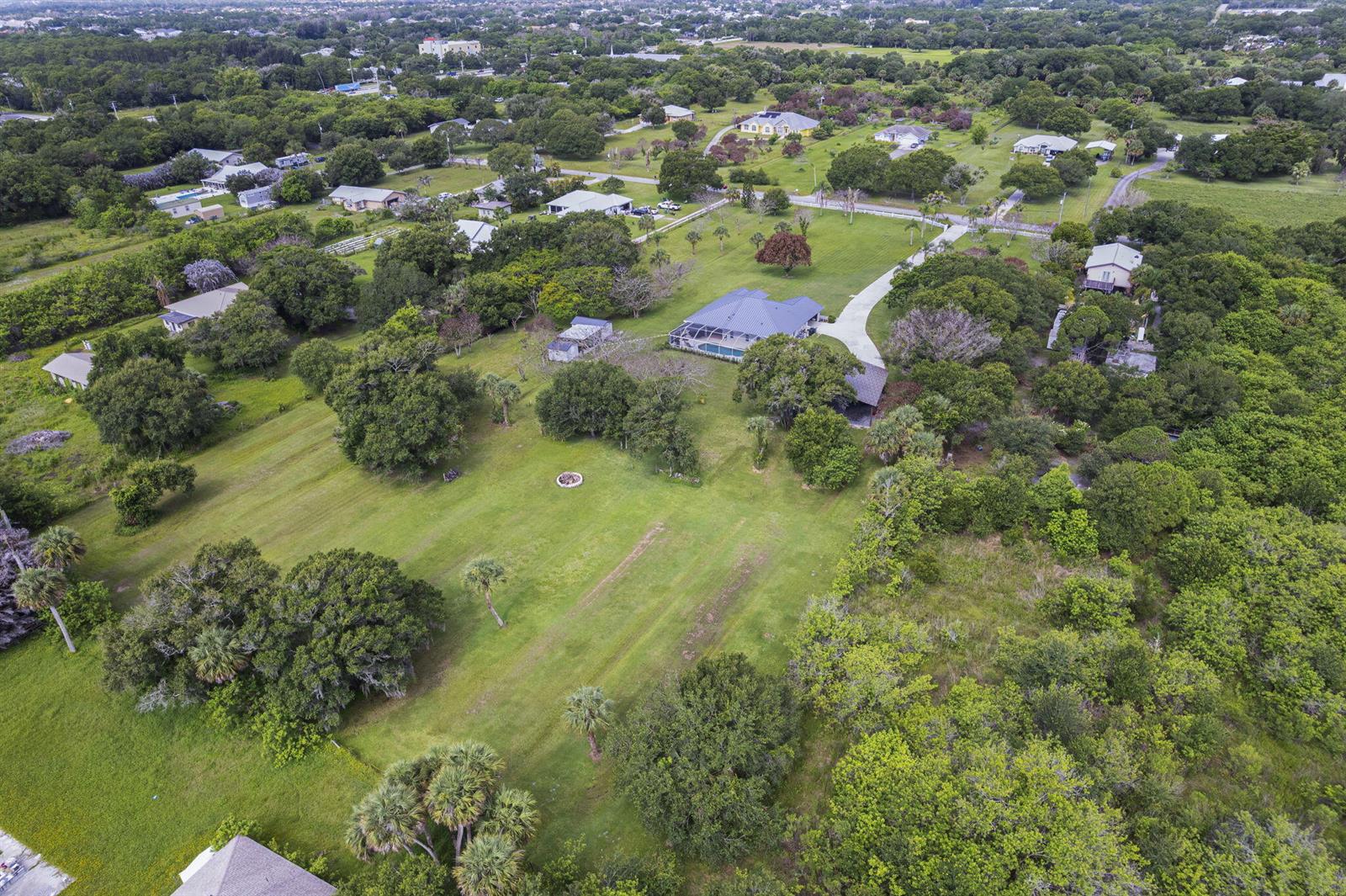 An aerial view shows a house with a pool and large yard surrounded by trees — 4800 Christensen Road, Fort Pierce FL 34981, FORT PIERCE, FL