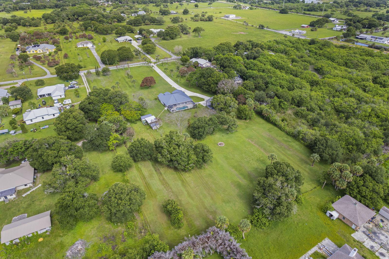 An aerial view shows a residential property with a house, pool, and large grassy yard — 4800 Christensen Road, Fort Pierce FL 34981, FORT PIERCE, FL