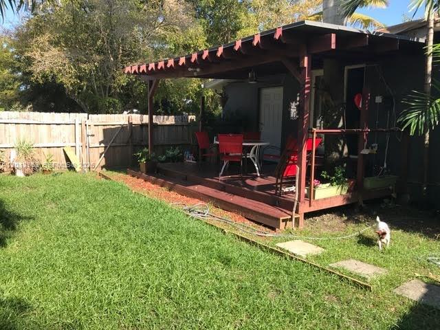 A backyard features a wooden deck with a covered patio and a small dog — 11400 NE 4 Ave # 2, Miami FL 33161, MIAMI, FL